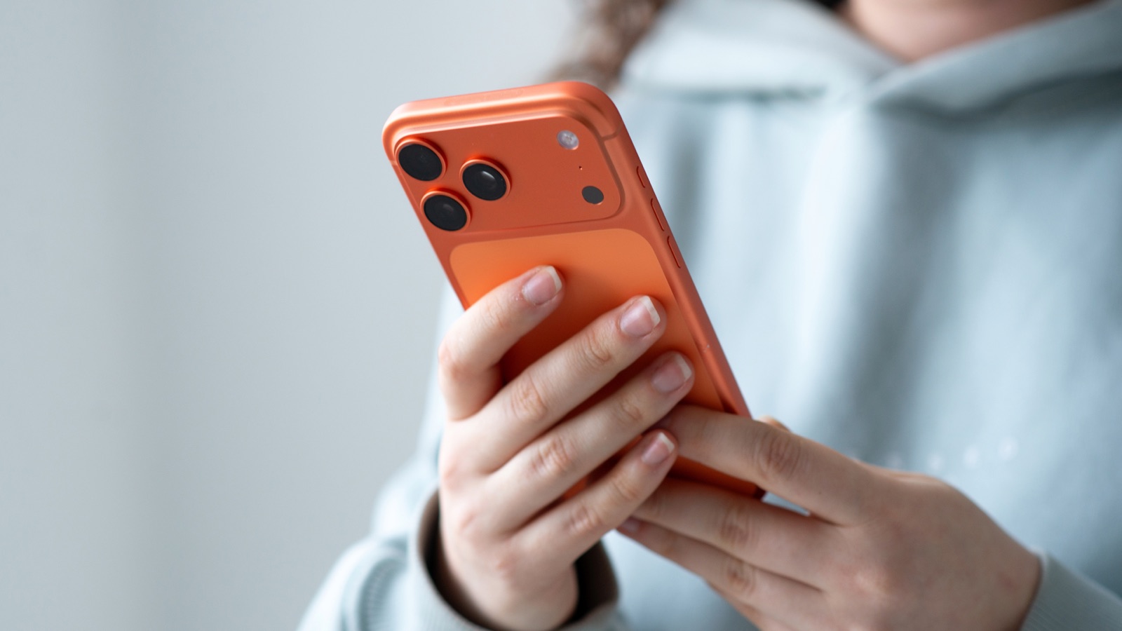 A person using an orange smartphone