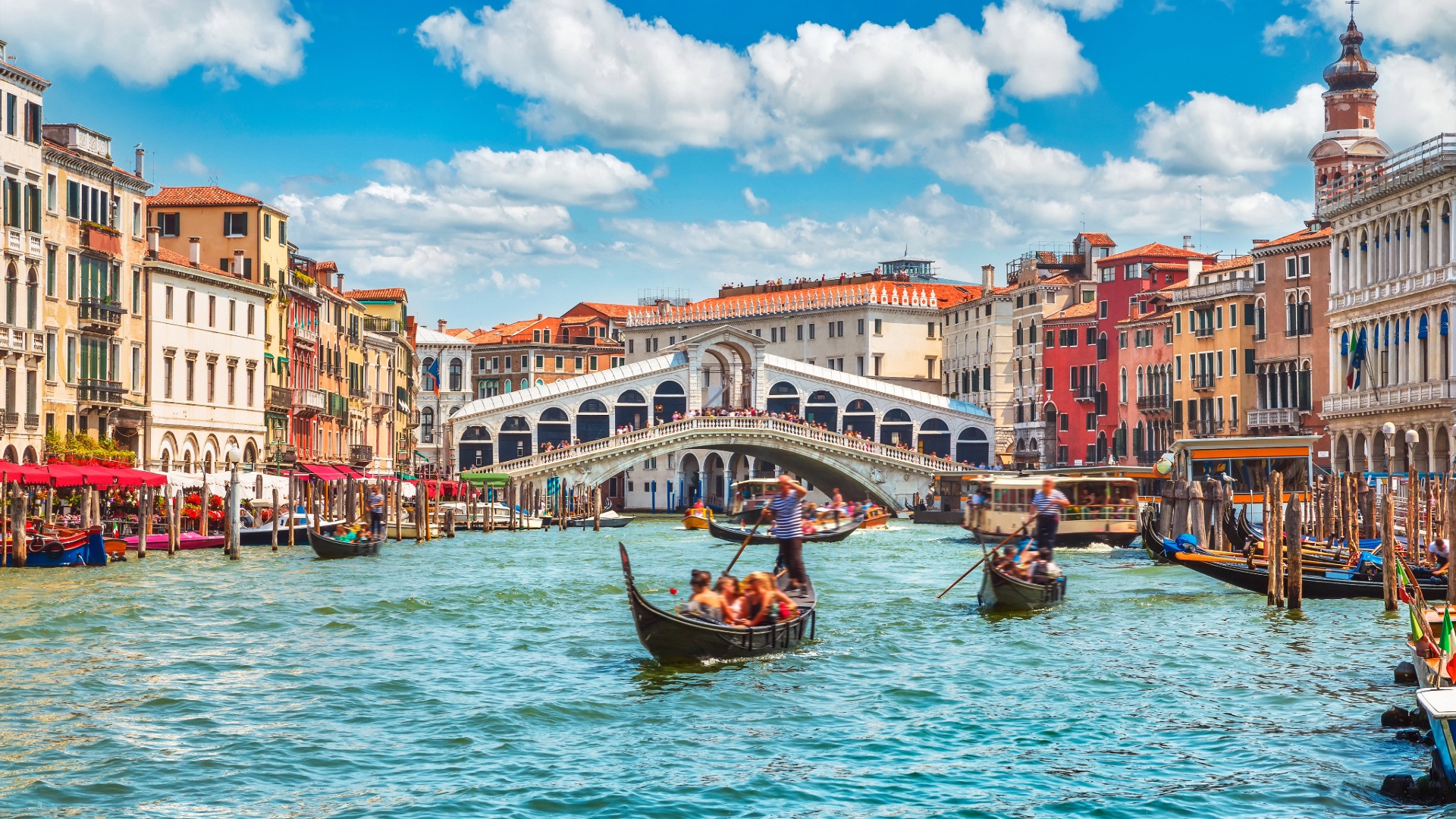 Gondolas traveling through Venice near the Rialto Bridge