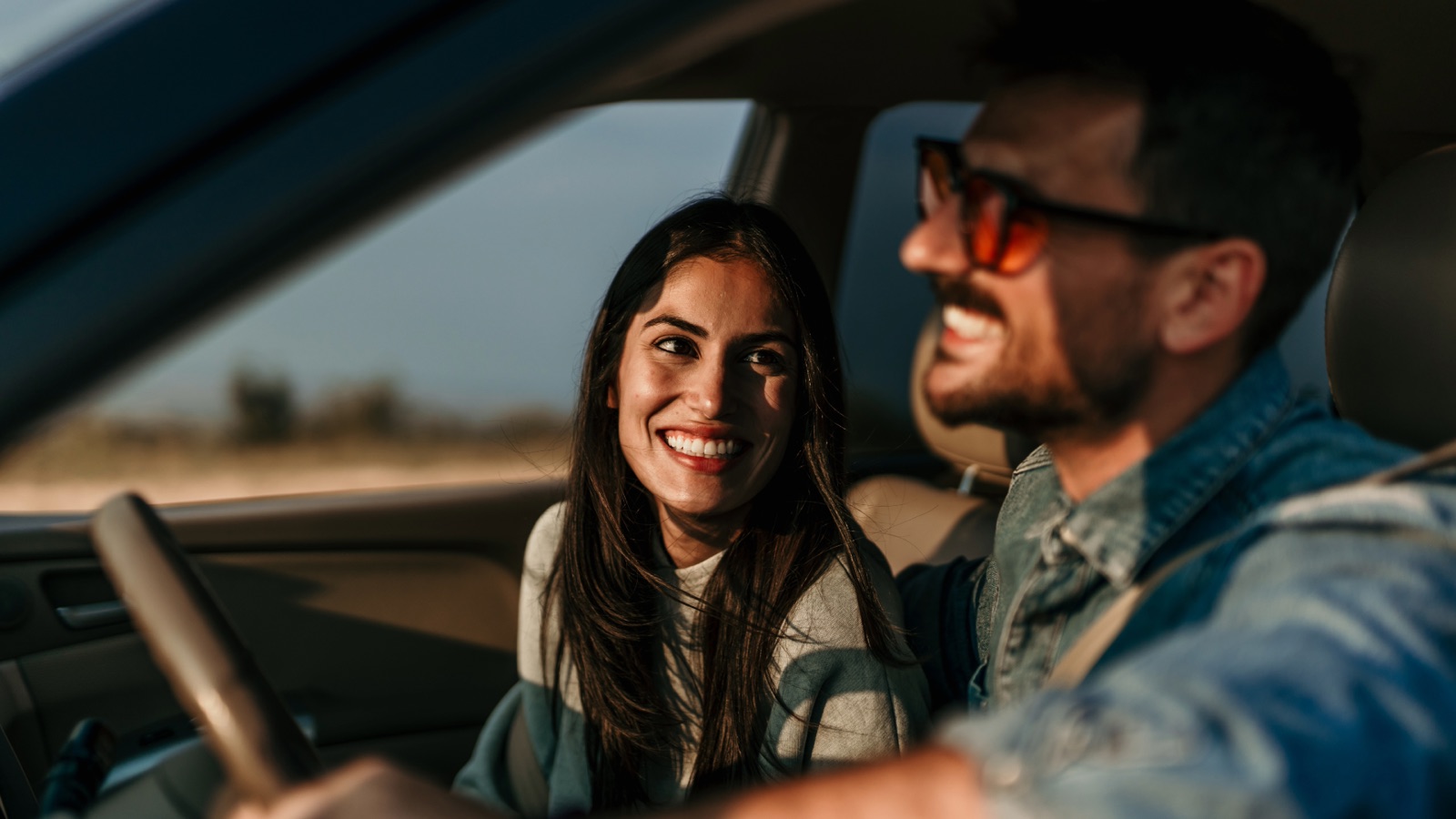 A smiling couple riding together in a car