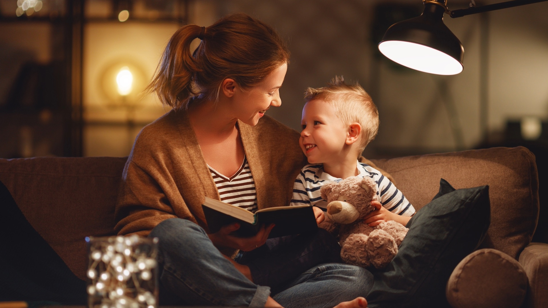 Mother reading with her young son at home